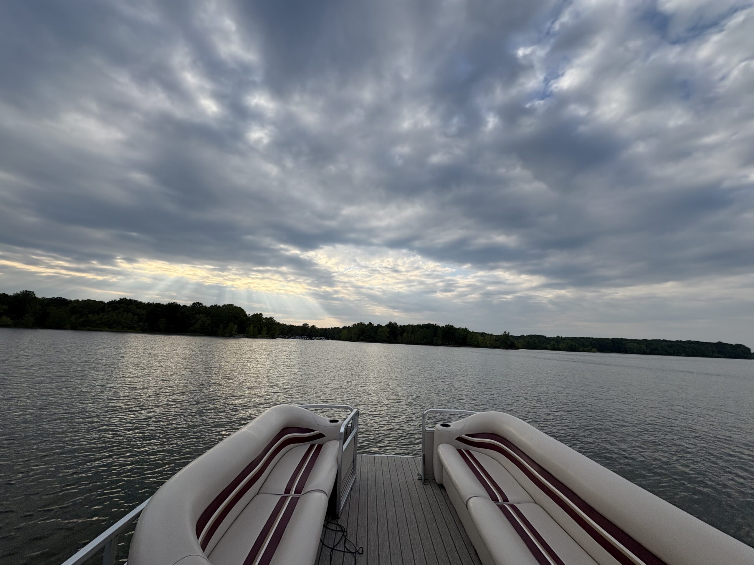 IMG_0751 The view of Berlin Lake from the back side of a pontoon boat. The water looks peaceful, and a blue bimini top provides shade on the boat.